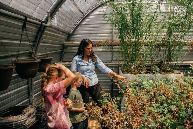 Ashley in greenhouse with students