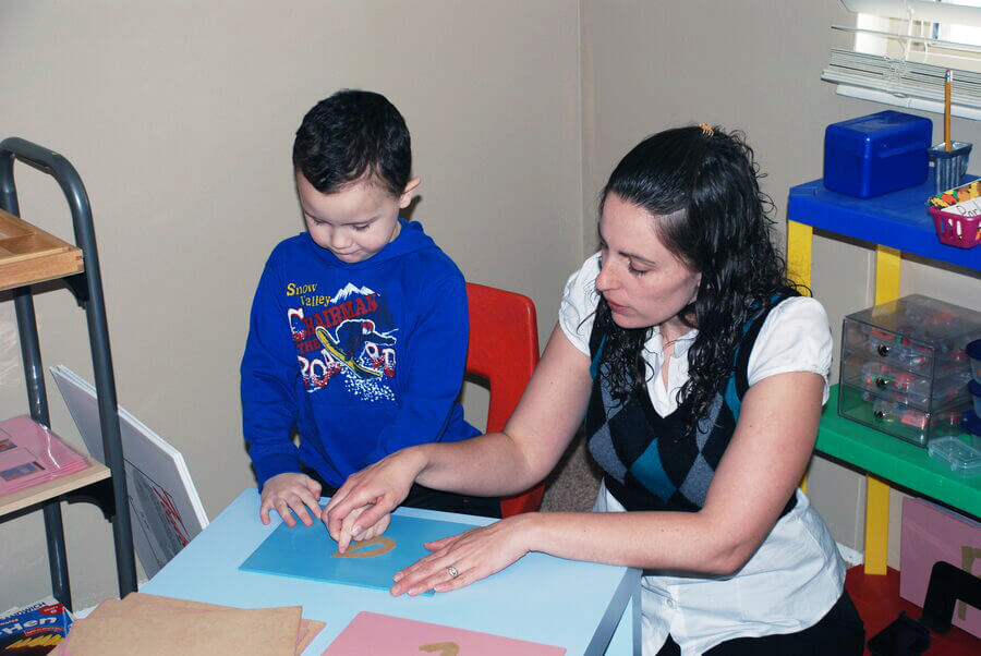 Ashley helping a student with his letters